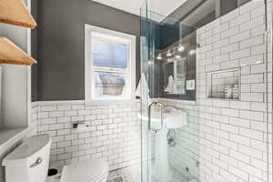 Updated bathroom with herringbone tiled floors and subway tiled shower/ walls