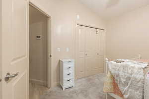 Carpeted bedroom with a closet and vaulted ceiling