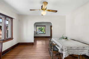 Dining room featuring dark wood-type flooring and ceiling fan