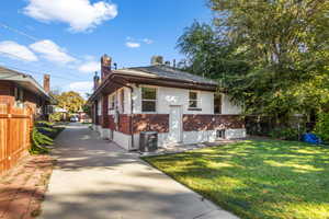 View of side of property with central AC and a lawn