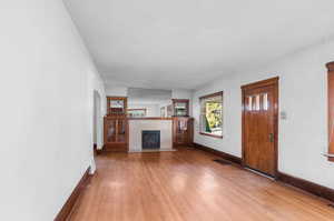 Unfurnished living room with a tile fireplace, a textured ceiling, and light wood-type flooring