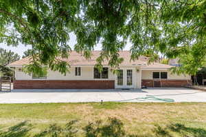 View of front facade featuring a front yard, french doors, and a patio area