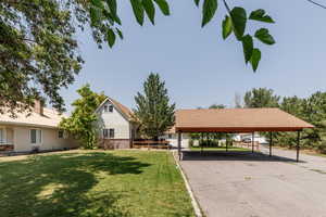 View of yard with a garage and a carport