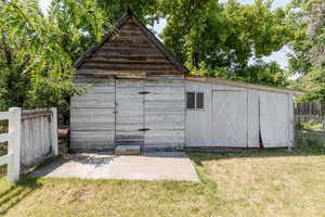 View of outdoor structure featuring a lawn