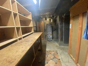 Basement featuring heating unit and strapped water heater