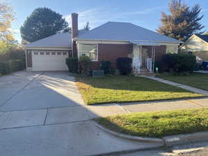 View of front of house featuring a garage, a front lawn, and central AC unit