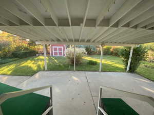 View of patio featuring a storage unit