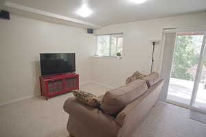 Living room with light carpet, a textured ceiling, and plenty of natural light