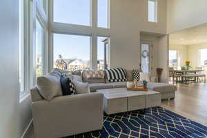 Living room with a towering ceiling and hardwood / wood-style flooring