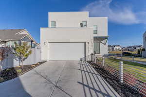 View of front facade featuring a front yard and a garage