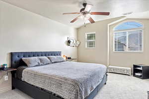 Bedroom with ceiling fan, light carpet, a textured ceiling, and vaulted ceiling