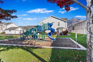 View of jungle gym featuring a yard and a mountain view