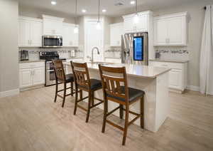 Large island with dual basin stainless steel sink and pendant lighting.