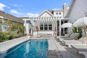 Rear view of property featuring a patio and a pergola