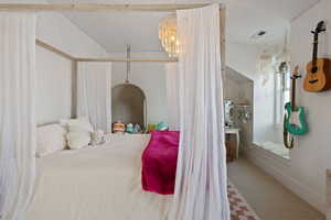 Carpeted bedroom featuring an inviting chandelier