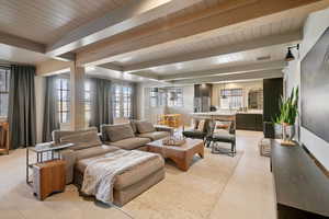 Living room with beamed ceiling, wooden ceiling, and light tile patterned floors