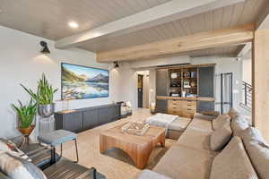 Tiled living room featuring beam ceiling