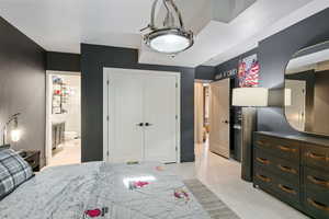 Tiled bedroom featuring a closet and a notable chandelier