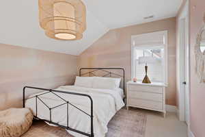 Carpeted bedroom with vaulted ceiling