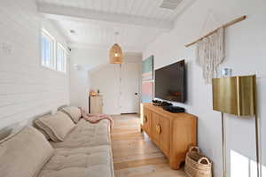 Living room featuring beam ceiling and light wood-type flooring