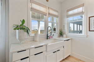 Interior space with light hardwood / wood-style floors, light stone counters, sink, and a wealth of natural light