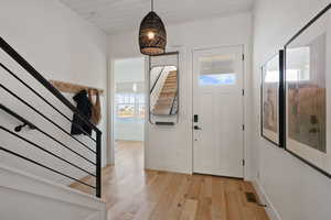 Foyer entrance with wood ceiling and light hardwood / wood-style floors