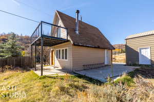 Rear view of house featuring a patio and an outdoor structure