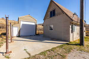 View of side of home featuring a garage and concrete drive.