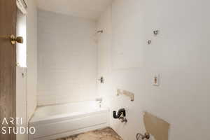 Bathroom with tiled shower / bath combo plumbing in place for full bath.