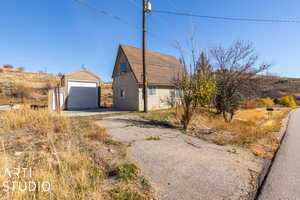 View of property exterior featuring a garage and an outbuilding