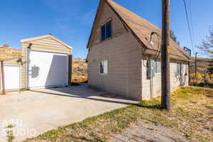 View of property exterior with an outbuilding and a garage