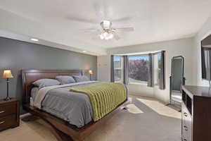 Carpeted bedroom featuring ceiling fan