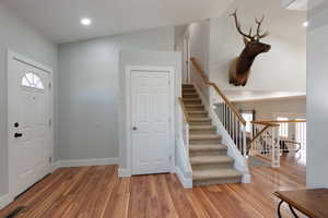 Entrance foyer with lofted ceiling and hardwood / wood-style flooring