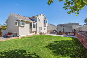 Rear view of house with a patio, a yard, and an outdoor fire pit