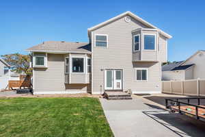 Rear view of house with a patio and a lawn