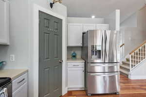 Kitchen featuring stainless steel appliances, light hardwood / wood-style flooring, and white cabinets