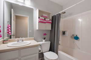 Full bathroom featuring toilet, shower / bath combo, and vanity