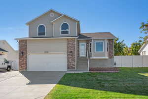 View of front of home featuring a front yard and a garage