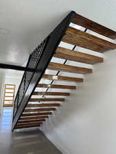 Stairs with beam ceiling and a textured ceiling