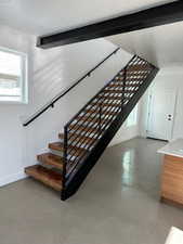 Stairway with concrete flooring and a textured ceiling