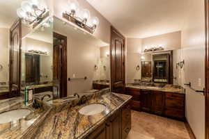 Bathroom featuring vanity, an inviting chandelier, and a textured ceiling