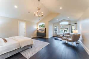 Bedroom featuring multiple windows, a notable chandelier, vaulted ceiling, and dark hardwood / wood-style flooring