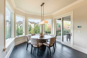 Dining space with crown molding, dark hardwood / wood-style floors, and a healthy amount of sunlight