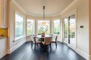 Dining space with crown molding, dark hardwood / wood-style flooring, and plenty of natural light