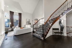 Interior space with high vaulted ceiling and hardwood / wood-style floors