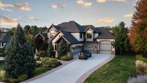 View of front of property featuring a garage and a lawn