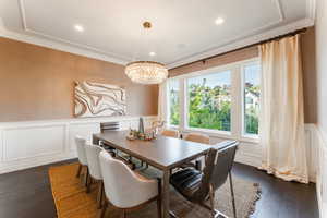 Dining space featuring ornamental molding, a notable chandelier, and dark hardwood / wood-style floors