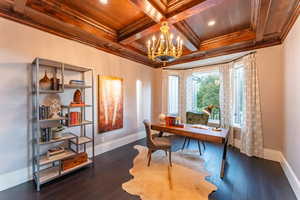 Office space with a notable chandelier, dark hardwood / wood-style floors, coffered ceiling, and crown molding