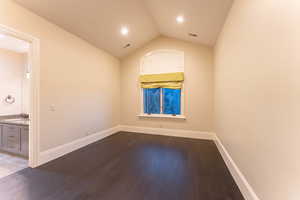 Unfurnished room with lofted ceiling, sink, and dark hardwood / wood-style flooring