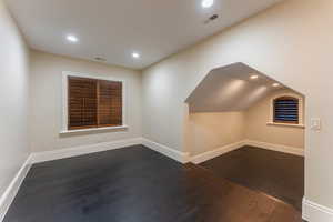 Bonus room with vaulted ceiling and dark hardwood / wood-style flooring